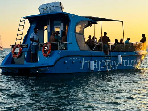 Passagiers ontspannen aan boord van de Benagil Grotten Catamarantocht vanuit Lagos