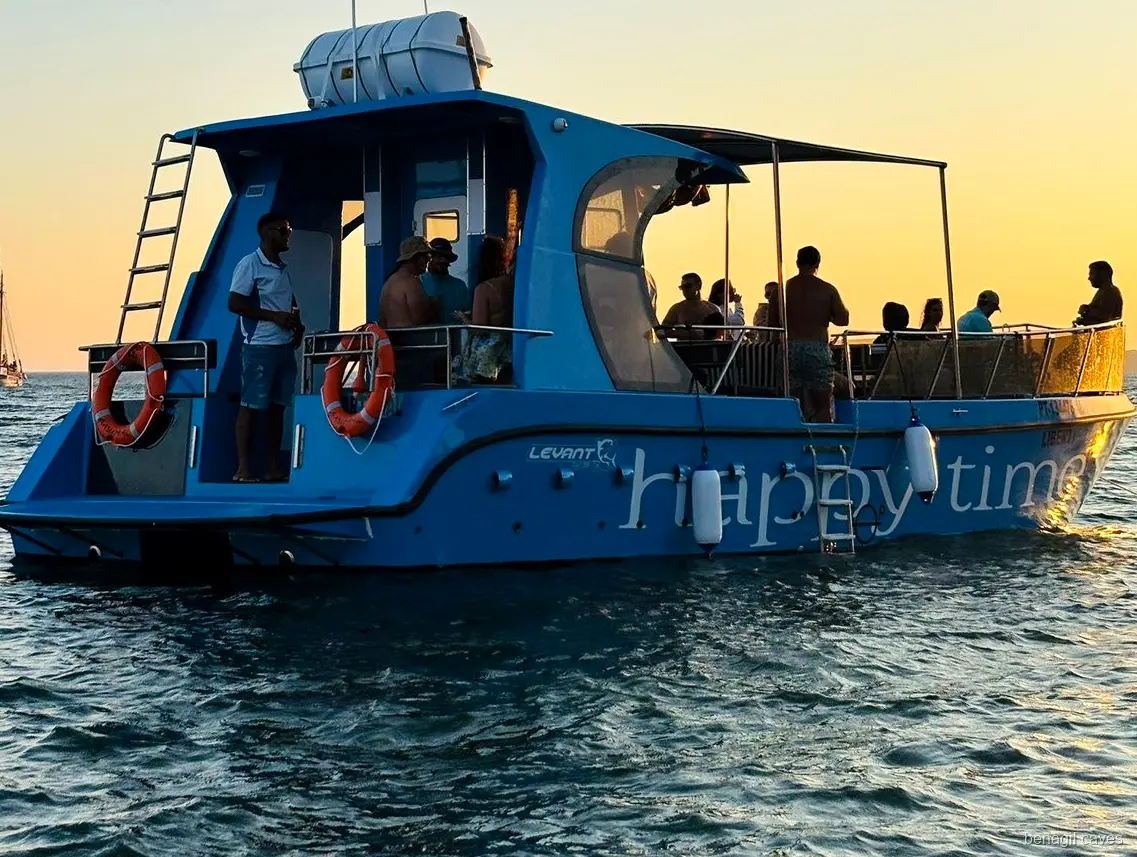Passagiers ontspannen aan boord van de Benagil Grotten Catamarantocht vanuit Lagos
