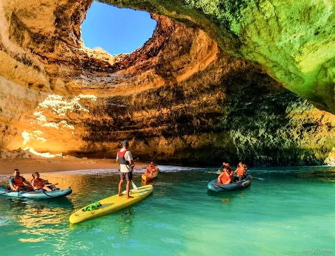 Guida che conduce un tour in kayak verso l'ingresso della grotta di Benagil