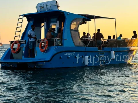 Pasażerowie odpoczywający na pokładzie katamaranu w drodze do Jaskini Benagil